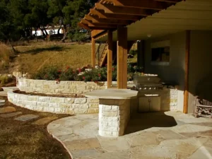 outdoor kitchen with natural stone and pergola in austin