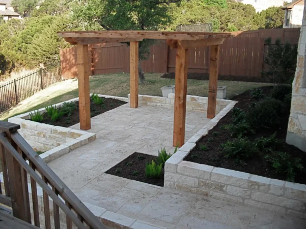 Light stone patio and retaining walls with a minimalist wooden pergola