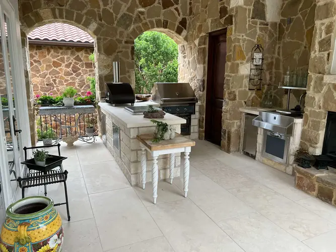 Stone Outdoor Kitchen with White Island in Barton Creek